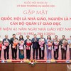 National Assembly Chairman Tran Thanh Man presents flowers to lawmakers who are teachers, and former teachers and education managers in Hanoi on November 20. (Photo: VNA)