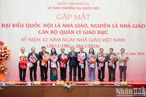 National Assembly Chairman Tran Thanh Man presents flowers to lawmakers who are teachers, and former teachers and education managers in Hanoi on November 20. (Photo: VNA)