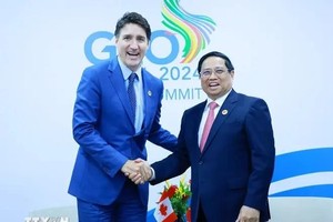 PM Pham Minh Chinh (R) shakes hands with his Canadian counterpart Justin Trudeau (Photo: VNA)