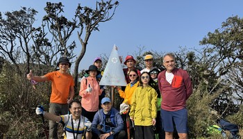 Trekkers pose for a group photo with the stainless steel pyramid on Mount Putaleng 