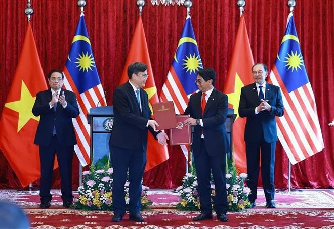 Vietnamese Prime Minister Pham Minh Chinh (L) and his Malaysian counterpart Anwar Ibrahim witness the exchange of a letter of intent on cooperation between the Viet Nam National University, Ho Chi Minh City and the National University of Malaysia. (Photo: VNA) Vietnamese Prime Minister Pham Minh Chinh (L) and his Malaysian counterpart Anwar Ibrahim witness the exchange of a letter of intent on cooperation between the Viet Nam National University, Ho Chi Minh City and the National University of Malaysia. (Photo: VNA)