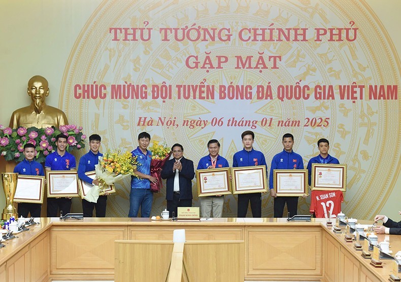 Prime Minister Pham Minh Chinh presents the first-class Labour Order to the national football team. (Photo: Tran Hai)