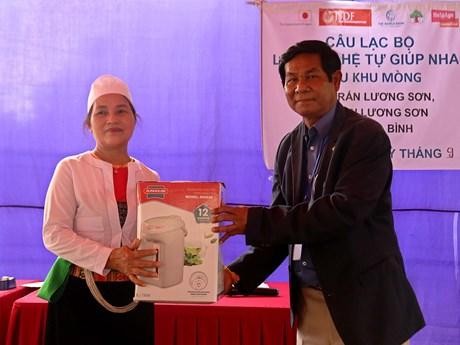 Toch Channy (R), an official of the Cambodian Ministry of Social Affairs, Veterans and Youth Rehabilitation, presents a gift to a representative of senior citizens in Luong Son district, Hoa Binh province, on September 21. (Photo: VNA)