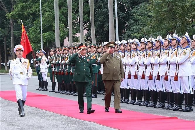 General Luong Cuong (L) and Divisional General Víctor Rojo Ramos review the guard of honour. (Photo: VNA)