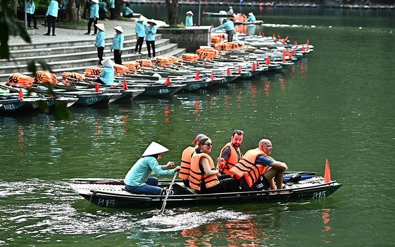 Foreign tourists visit Trang An scenic landscape in Ninh Binh Province. 