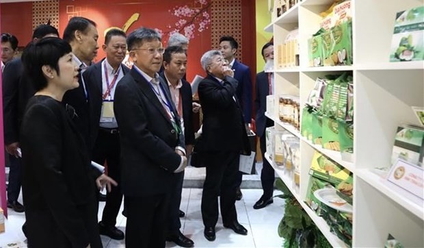 Representatives of Singaporean businesses visit a Vietnamese booth on the sidelines of conference. (Photo: VNA)