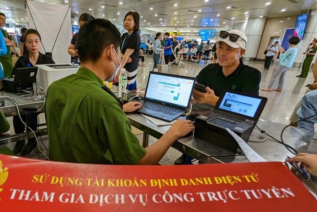 An air passenger is supported to activate his eID at Noi Bai International Airport on May 31. (Photo: chinhphu.vn)