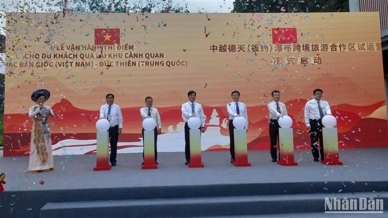 Delegates perform a ceremony to start the pilot operation of tours to Ban Gioc-Duc Thien Waterfall scenic area.