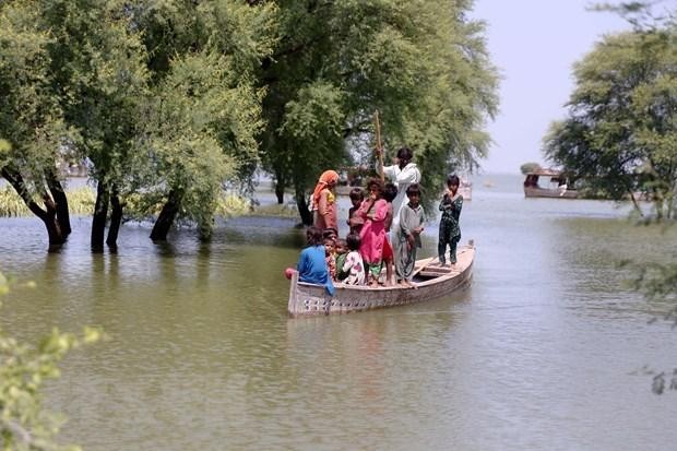 People go by boat at a flooded area in Sindh province of Pakistan. (Photo: Xinhua/VNA)