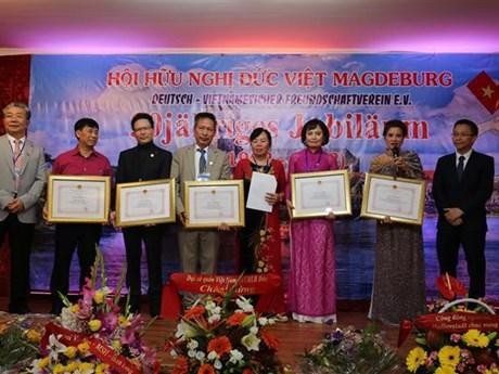 Chu Tuan Duc (1st from R), Minister-Counsellor and Deputy Head of Mission at the Vietnamese Embassy, presents certificates of merit to members with outstanding contributions to the association at the ceremony. (Photo: VNA)