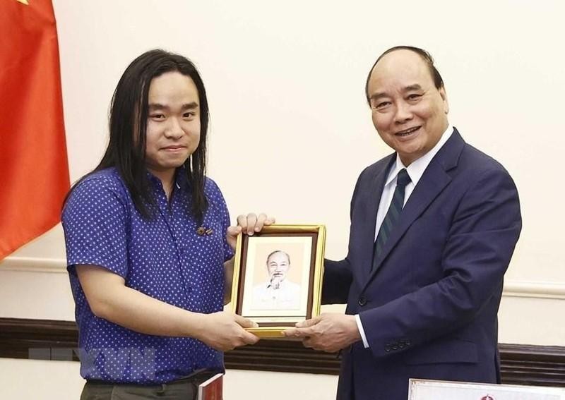 Writer Nguyen Binh (R) presents President Nguyen Xuan Phuc with a bilingual version of Truyen Kieu (Photo: VNA)