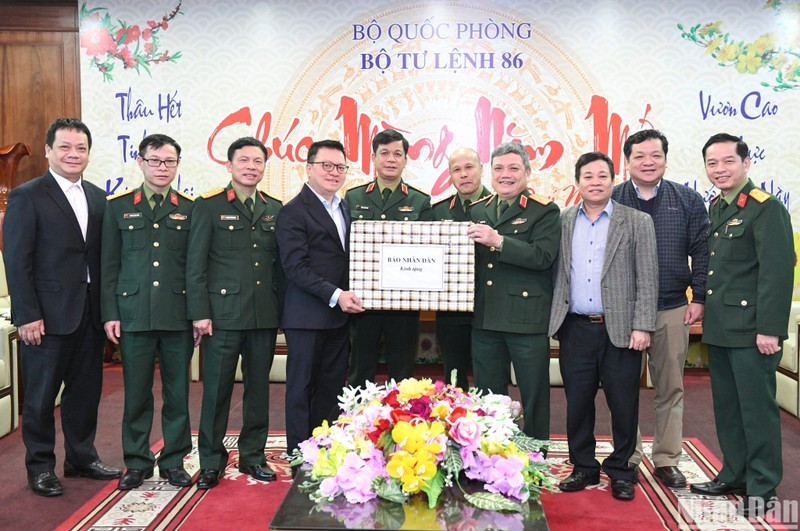 Editor in Chief of Nhan Dan Newspaper Le Quoc Minh (4th, from left) presents Tet gifts from Nhan Dan Newspaper to officers and soldiers of the Cyber Command. (Photo: Thanh Dat)