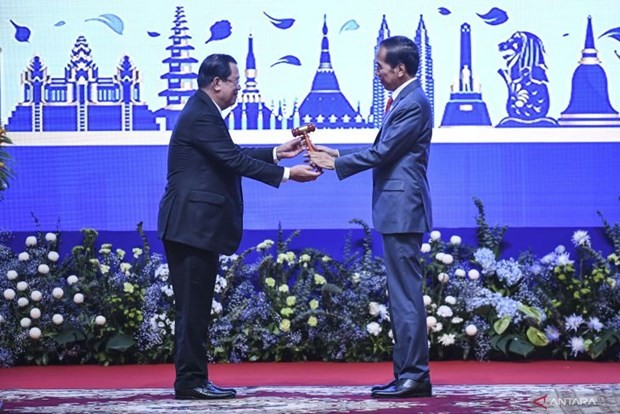 Indonesian President Joko Widodo (right) receiving the ASEAN chairmanship relay from Cambodian Prime Minister Hun Sen (left) in Phnom Penh, Cambodia on November 13, 2022. (Photo: VNA)
