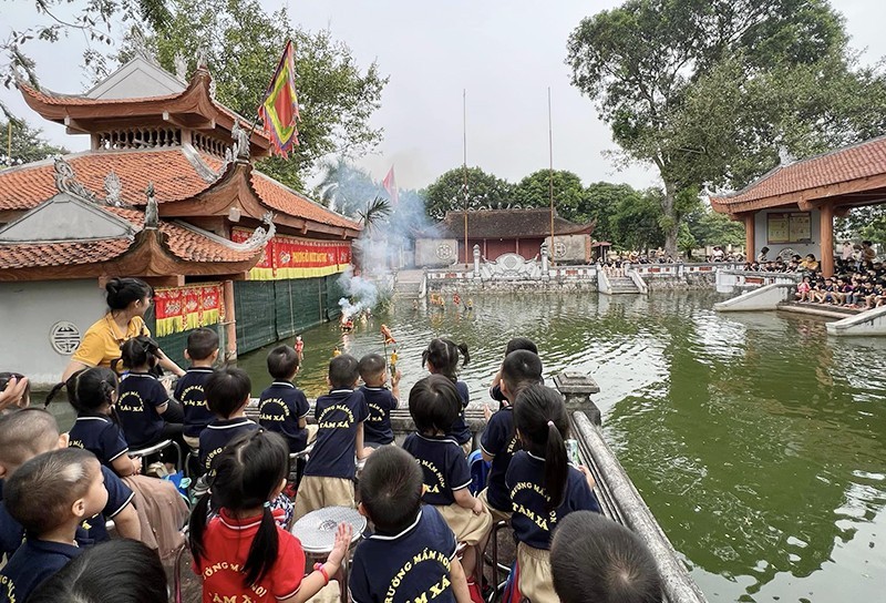 Students watch a water puppet show in Dao Thuc Water Puppet Ward, Thuy Lam Commune, Dong Anh District.