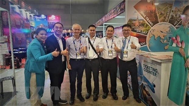 Hoang Minh Tri,head of the Representative Office of Vietnam Airlines in Malaysia, (third from right) and other partners at the fair. (Photo: VNA)
