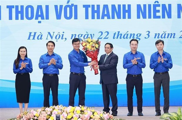 PM Pham Minh Chinh presents flowers to congratulte the Ho Chi Minh Communist Youth Union on its 92nd anniversary at the dialogue on March 22. (Photo: VNA)