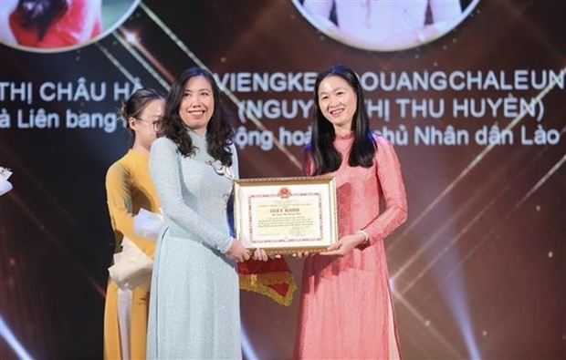 Deputy Minister of Foreign Affairs Le Thi Thu Hang (left) gives a certificate of merit to a candidate who won the title "Ambassador of Vietnamese language". (Photo: VNA)