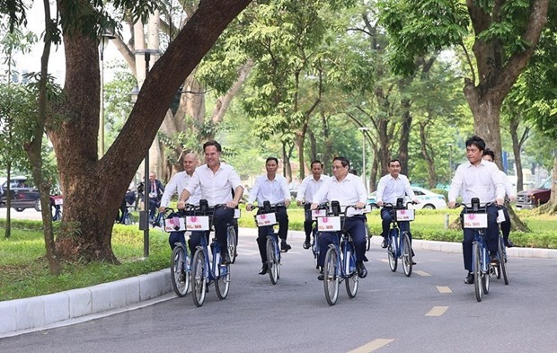 Prime Minister Pham Minh Chinh and Dutch Prime Minister Mark Rutte took a cycling tour to explore Hanoi's beauty. (Photo: Duong Giang/VNA) 