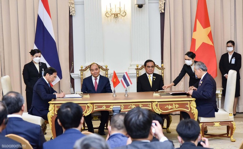 Vietnamese President Nguyen Xuan Phuc (sitting, left) and Thai Prime Minister Prayut Chan-o-cha (sitting, right) witness the signing of the Plan of Action on Implementing the Thailand – Vietnam Strengthened Strategic Partnership 2022 – 2027. (Photo: baoquocte.vn)