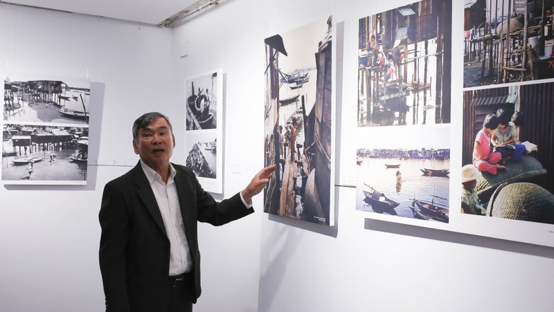 Photographer Ong Van Sinh introduces his photos to visitors. (Photo: toquoc.vn)