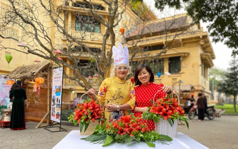 Visitors pose with baskets of red cotton flowers at the museum (Photo: Vietnam National Museum of History)