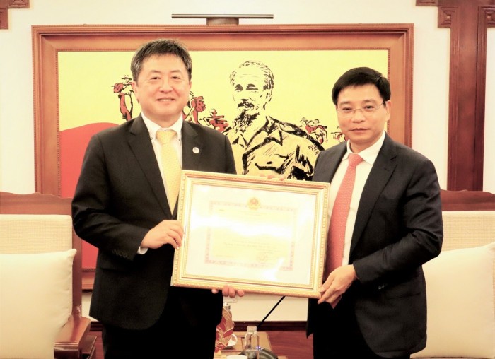 Minister of Transport Nguyen Van Thang (right) presents the insignia “For the development of Vietnam's transport sector” to Shimizu Akira, Chief Representative of the Japan International Cooperation Agency (JICA) Vietnam Office (Photo: baogiaothong.vn)