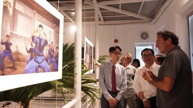 French photographer Philippe Marinig (R) introduces his photo to visitors at the exhibition (Photo: thethaovanhoa.vn)