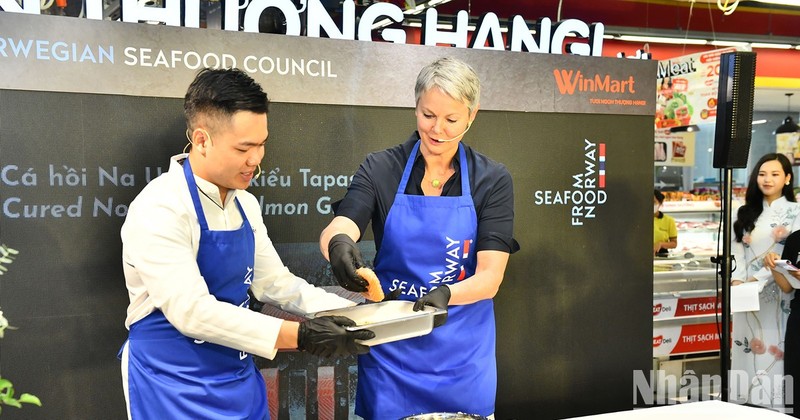 Norwegian Ambassador to Vietnam Hilde Solbakken joins a professional chef in processing and cooking top-class Norwegian salmon.