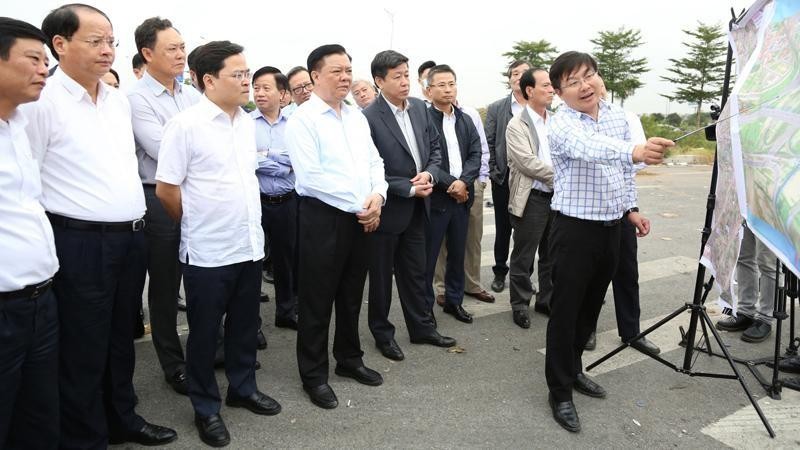 Politburo member Dinh Tien Dung surveys the field and listens to the report on the implementation of the Belt Road No.4 passing through Bac Ninh province.