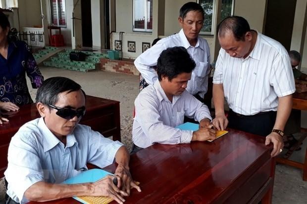 Visually impaired people are assisted to learn Braille. (Photo: VNA)