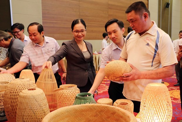 Participants look at products made from bamboo at the event. (Photo: VNA)