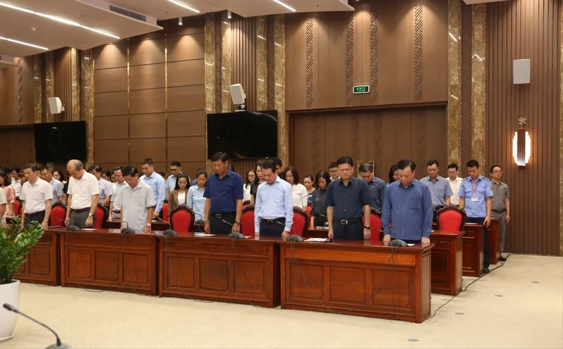 Secretary of Hanoi Party Committee Dinh Tien Dung and other staff hold a moment of silence for victims of the fire. (Photo: NDO)