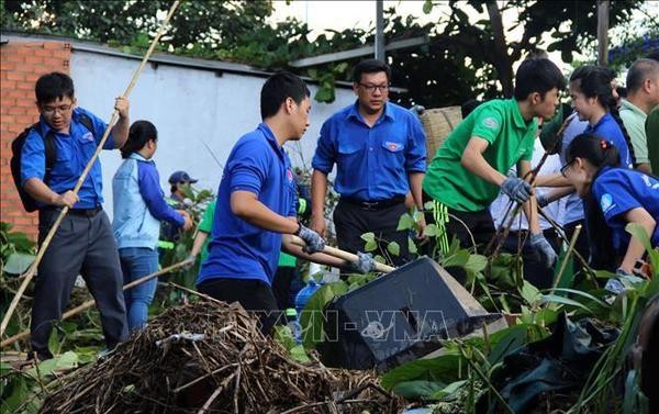 Young people clean up the environment. (Photo: VNA)