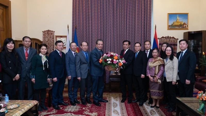 Ambassador Dang Minh Khoi presents flowers to the Lao Embassy representative. (Photo: Thanh The)