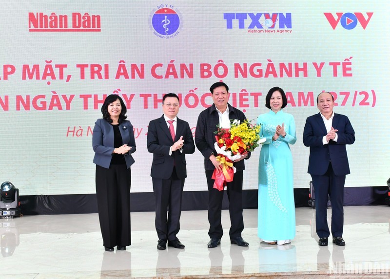 Leaders of press agencies present flowers to Deputy Health Minister Do Xuan Tuyen. (Photo: Dang Khoa)