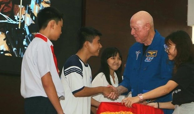 Astronaut Michael Baker and local students at the event. (Photo: VNA)