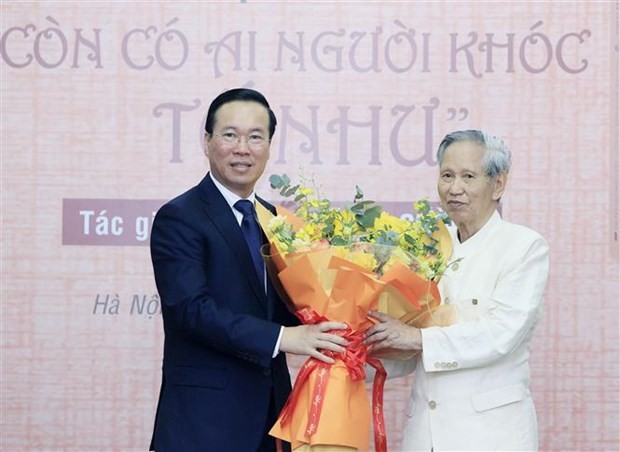 President Vo Van Thuong presents congratulating flowers to writer Vo Ba Cuong (Photo: VNA)