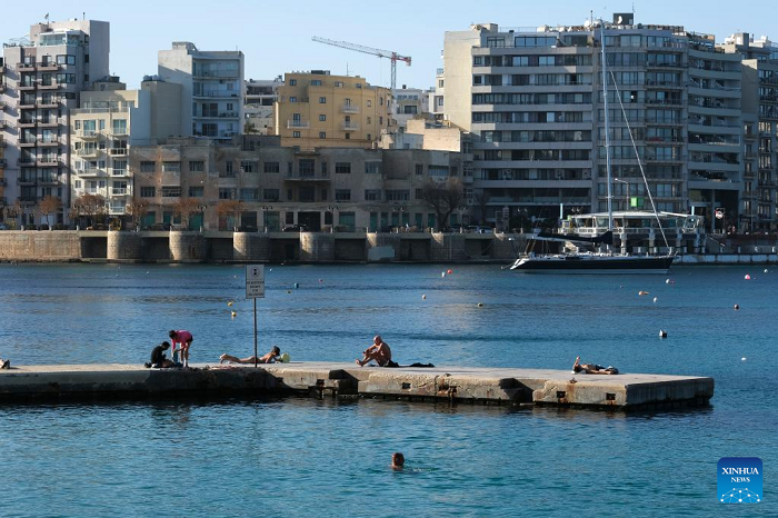 People spend time at the seaside of the Mediterranean Sea in Sliema, Malta, on Dec. 16, 2022. The maximum temperature reached 24 degrees Celsius in Malta on Friday, the warmest December day in almost 60 years, according to the country's meteorological office. (Photo: Xinhua)