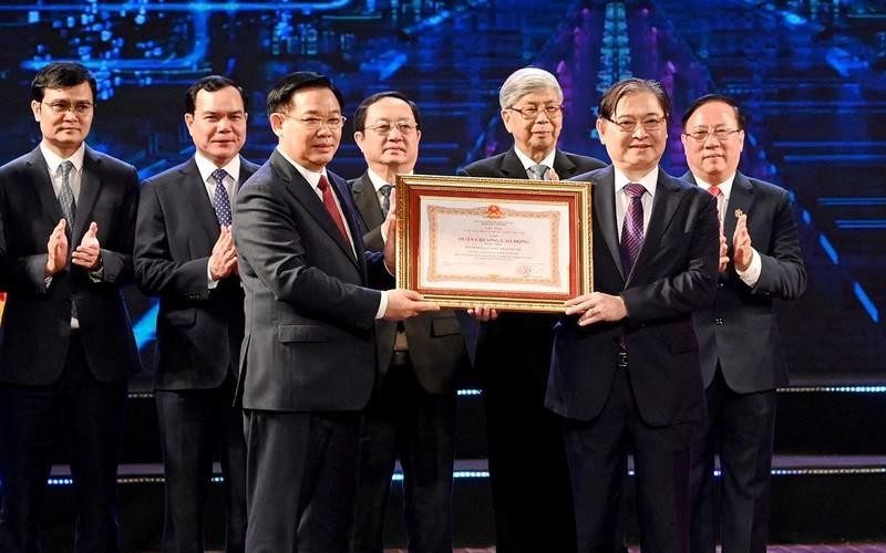 National Assembly Chairman Vuong Dinh Hue presents the first-class Labour Order to VIFOTEC President Phan Xuan Dung. (Photo: NDO)