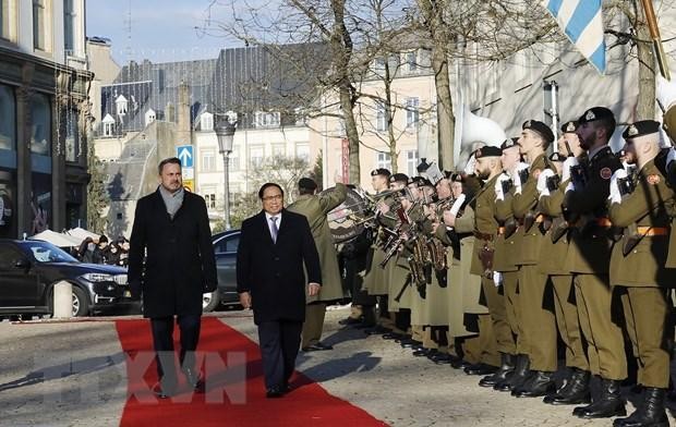 Prime Minister Pham Minh Chinh (R)and his Luxembourg counterpart Xavier Bettel review the honor guard (Photo: VNA)