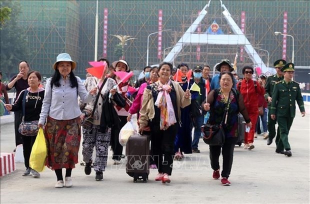 Chinese tourists cross Ho Kieu Bridge at the Lao Cai International Border Gate in Lao Cai province on March 15. (Photo: VNA)