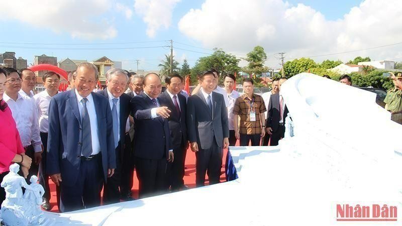 President Nguyen Xuan Phuc and other leaders and former leaders of the Party and State look at the model of monument commemorating people officials, soldiers and students from the south who gathered in the northern region during the war. (Photo: NDO)