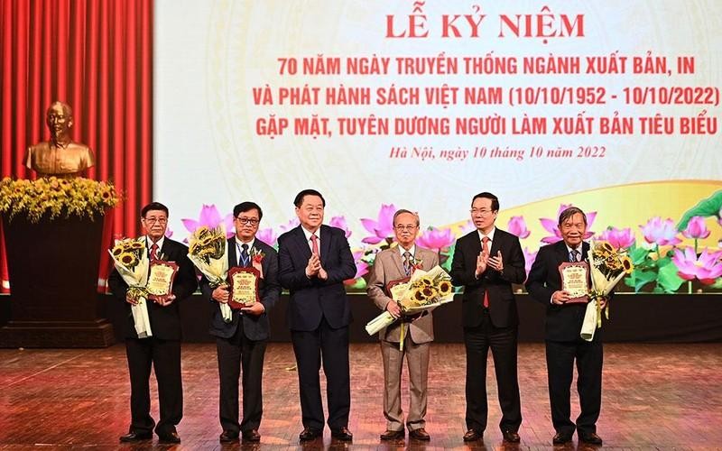 Politburo member Vo Van Thuong and Party official Nguyen Trong Nghia presents honourary badges to five senior officials in the book publishing sector. (Photo: the organising board)