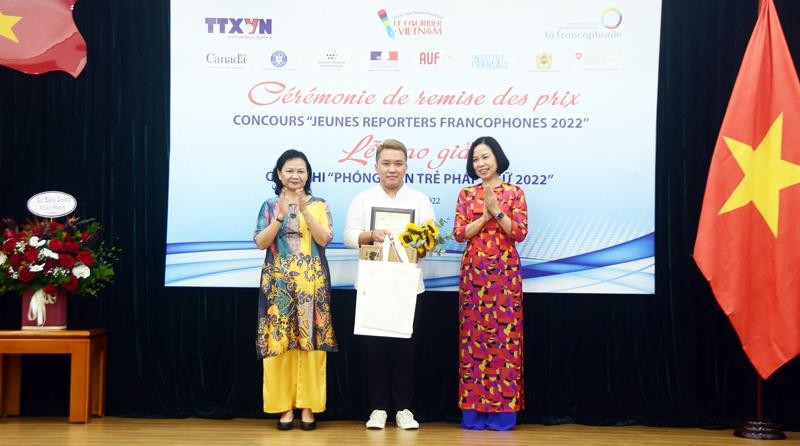 The first-prize winner Ho Ngoc Vinh Nguyen (centre) receive his award from VNA General Director Vu Viet Trang (R) and Tran Thi Mai Yen, acting Chief Representative of the OIF in the Asia-Pacific region. (Photo: VNA) 