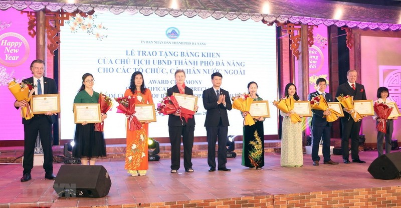 Representatives of foreign collectives and individuals receive certificates of merit for their contributions to Da Nang's development at the gathering on January 6. (Photo: VNA) 