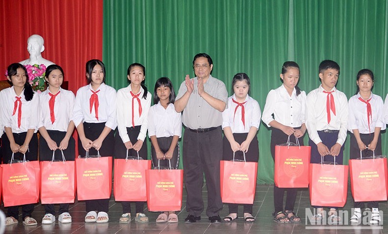 Prime Minister Pham Minh Chinh presents gifts to children at the School for Disabled Children of Ben Tre. (Photo: NDO) 