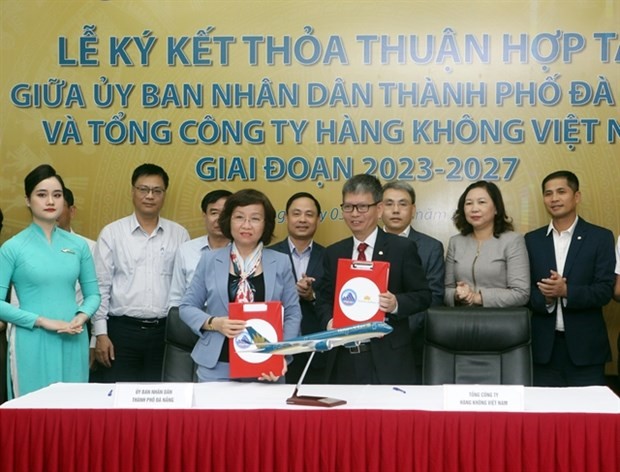 Deputy General Director of Vietnam Airlines Trinh Ngoc Thanh (front right) and Deputy Chairwoman of the Da Nang People's Committee Ngo Thi Kim Yen sign the cooperation agreement for 2023-27. (Photo: VNA) 