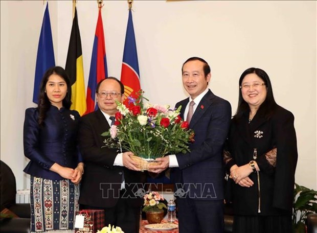 Vietnamese Ambassador to Belgium and Luxembourg Nguyen Van Thao (R) presents flowers to Lao Ambassador to Belgium and the EU Phoukhong Sisoulath at the exchange event. (Photo: VNA) 