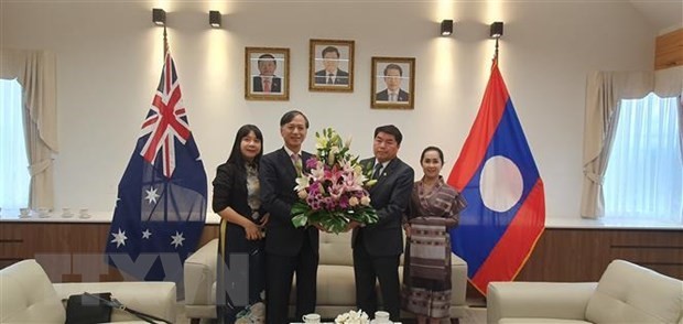 Vietnamese Ambassador to Australia Nguyen Tat Thanh (second, left) congratulates his Lao counterpart on the Bunpimay festival. (Photo: VNA) 