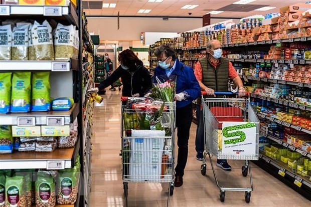 People buy goods in a supermarket in Milan, Italy. (Photo: AFP/VNA)
